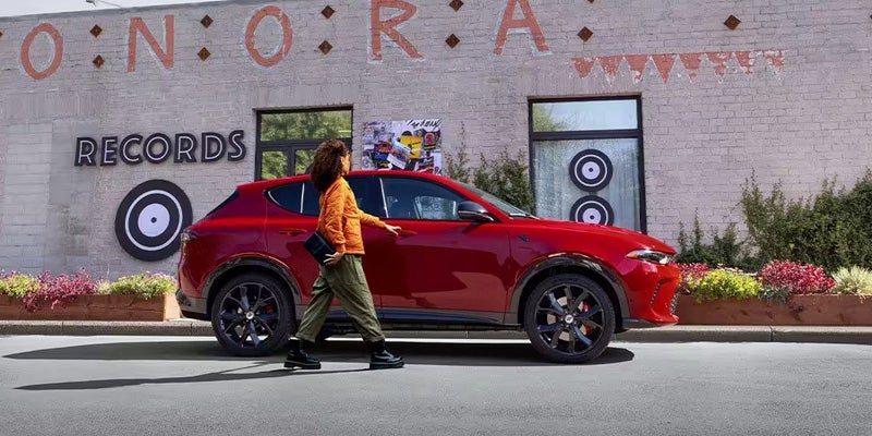 right profile of a red 2024 dodge hornet with a person appraoaching the passenger side